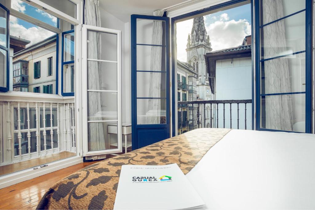 1 dormitorio con 1 cama y ventanas grandes en Casual Gurea, en Bilbao