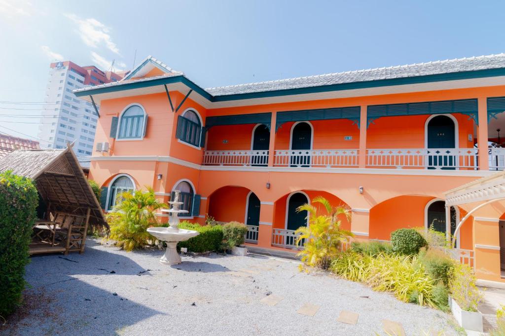 an orange building with a courtyard in front at Venice Hotel Hua Hin in Hua Hin