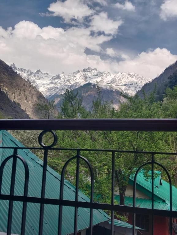 a view of a snow covered mountain from a balcony at Himvilla Kasol in Jāmb