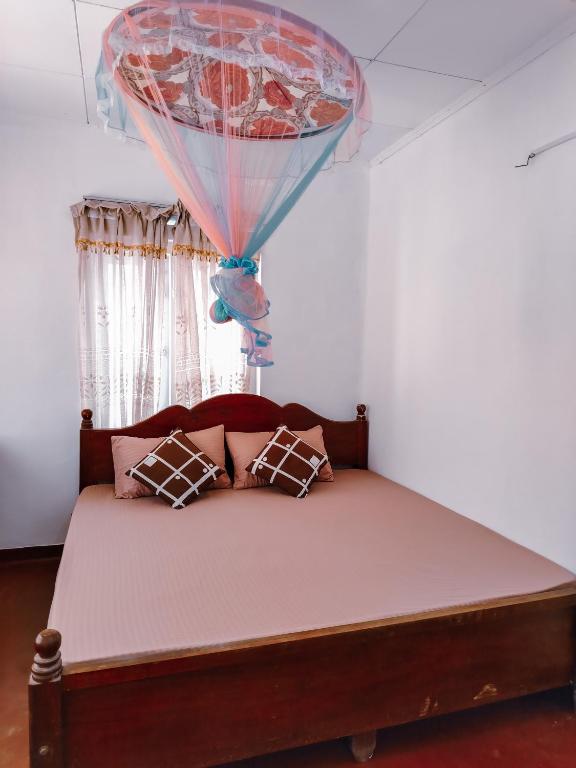 a bedroom with a bed with a window at Shan Inn Midigama in Midigama East