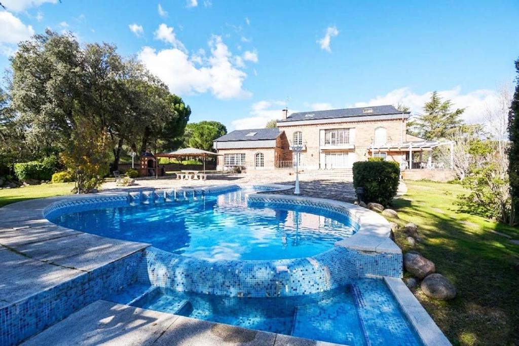 a swimming pool in the backyard of a house at Villa la cantera in Guadarrama