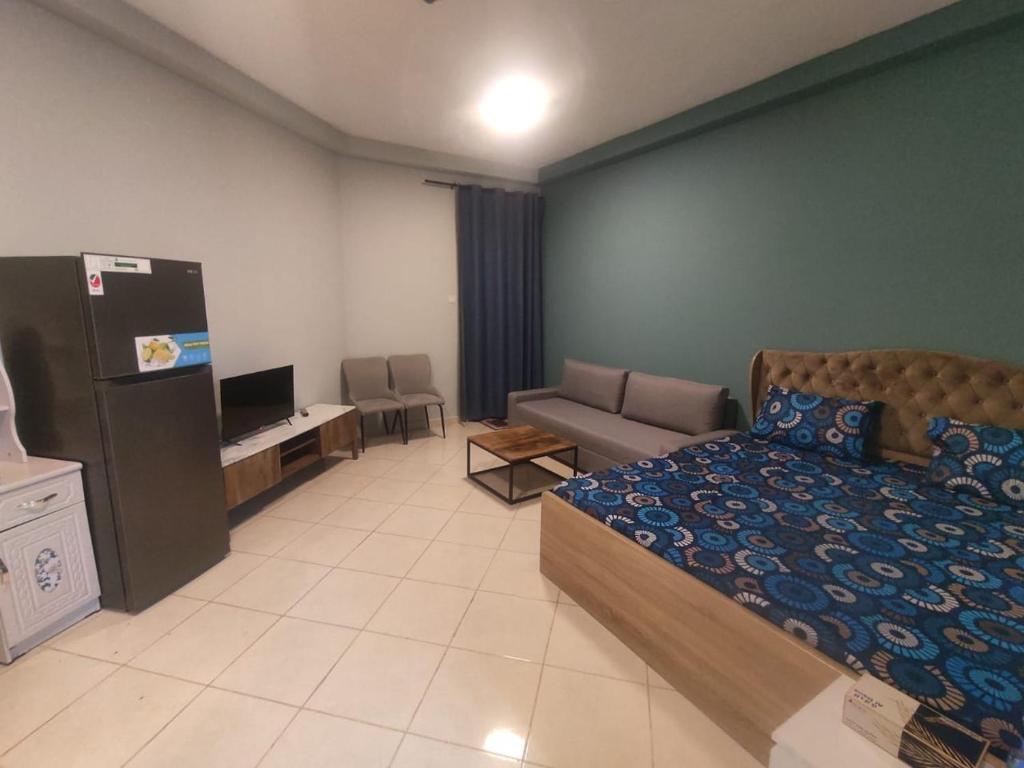 a bedroom with a bed and a tv and a couch at Trendy Studio In Orient Towers Ajman in Ajman 