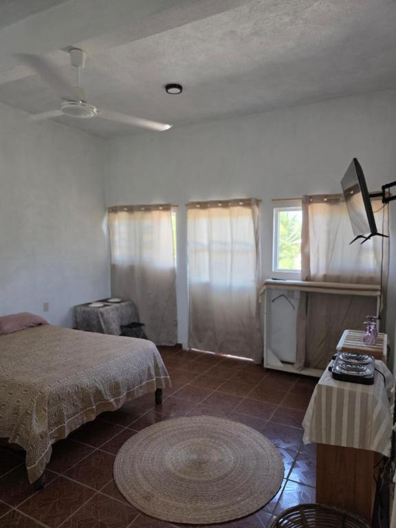 a bedroom with a bed and a table and a window at Estudio Arena in Brisas de Zicatela