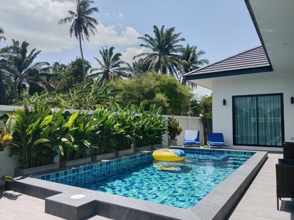 a swimming pool with a pool noodle in the middle of a house at Niramit Pool Villa in Ban Chong Phli