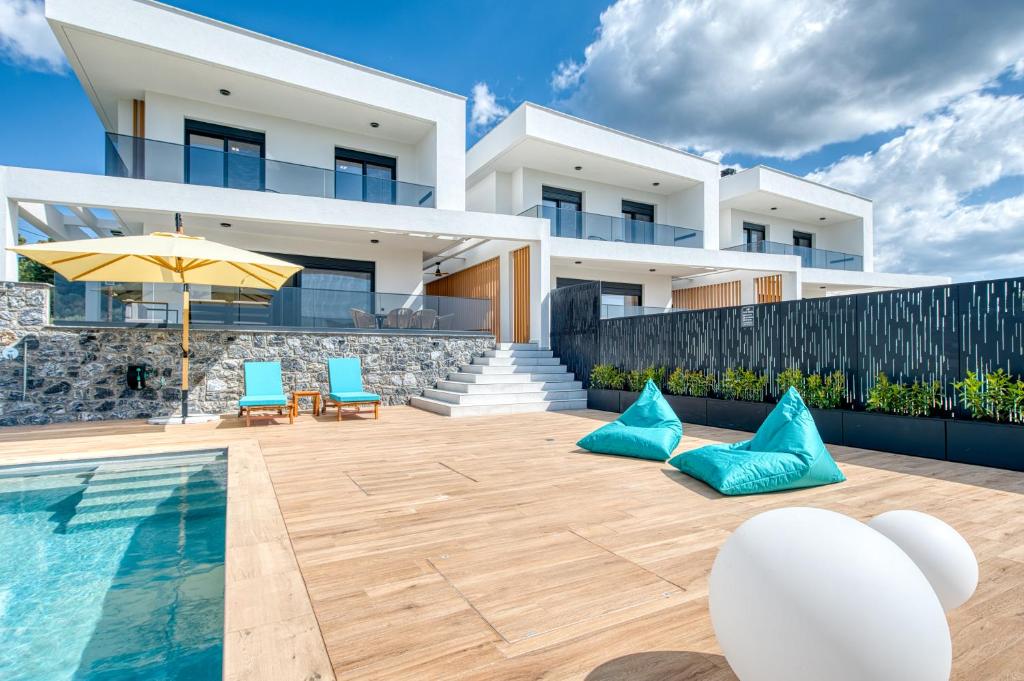 a villa with a swimming pool and a house at Inception Luxury Villas in Nea Skioni