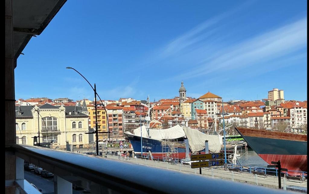 a view of a city with boats in a harbor at Patxiren etxea in Bermeo