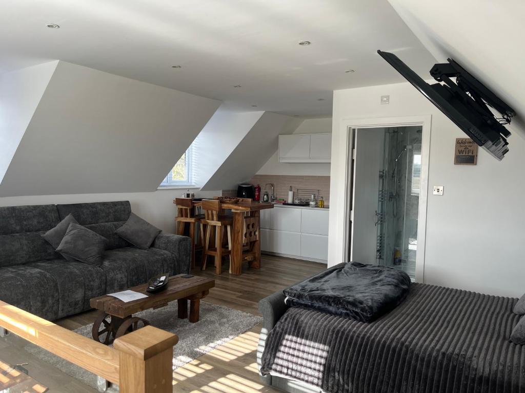 a living room with a couch and a table at Tollgate Annexe in Ashford