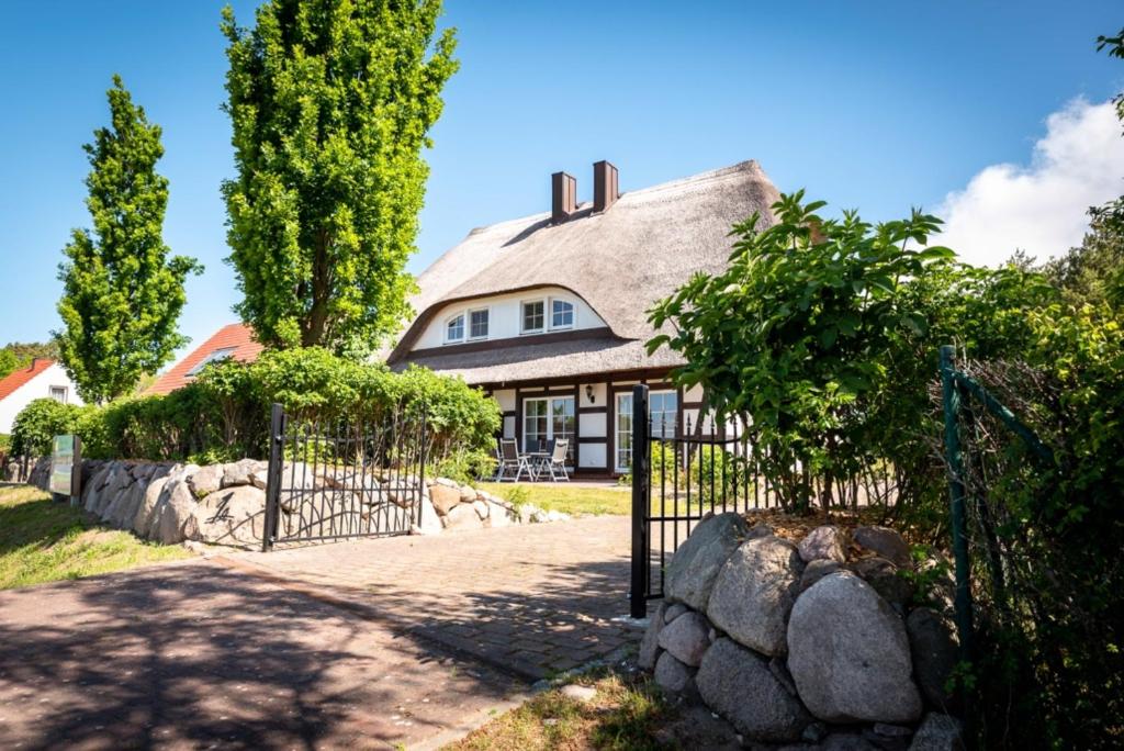 a house with a gate in front of it at Reethus-am-Hafen Reetdachhaus Hafenblick mit Garten und Blick aufs Wasser in Rankwitz