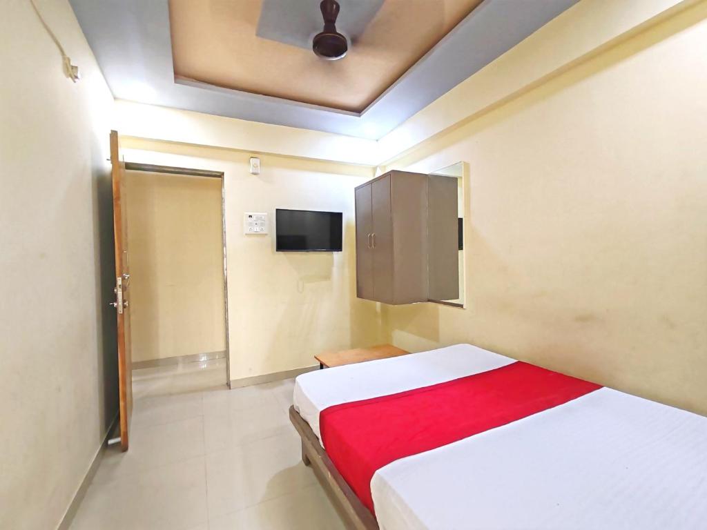 a bedroom with a bed with a red blanket at Hotel Krantiveer in Kālundri