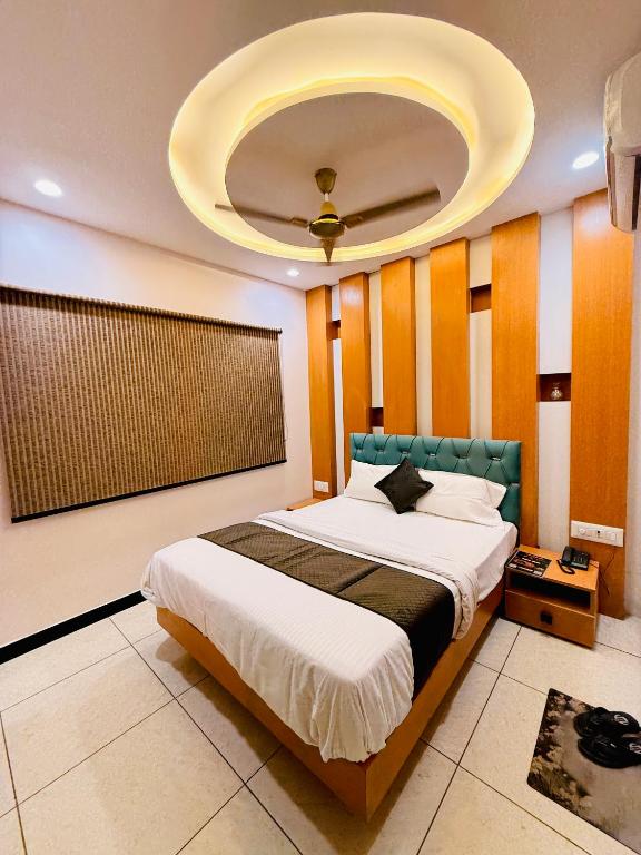 a bedroom with a large bed with a ceiling at Hotel Hira Palace in Ujjain