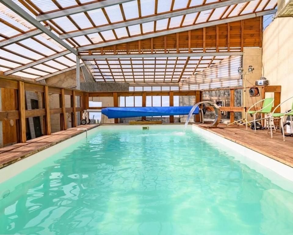 a large swimming pool with a pool slide in a building at האלפים של הכרמל ומצפה העמקים- וילה ומלונית מול נוף הצפון in Talpiyyot