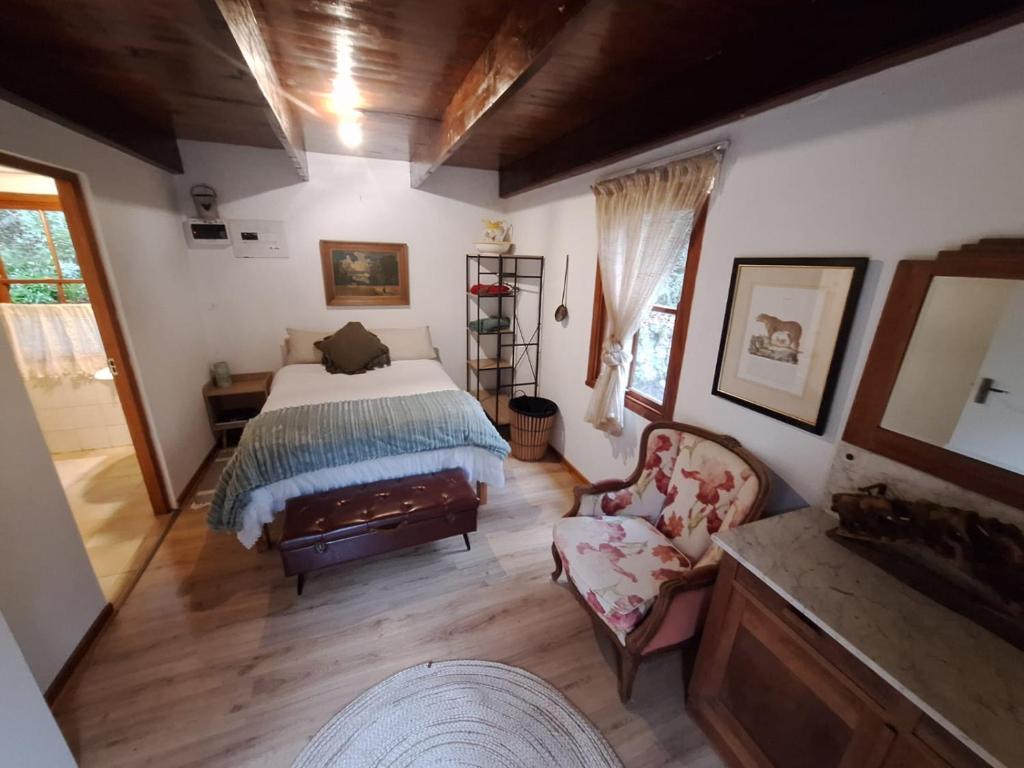 a bedroom with a bed and a chair at Bubuhle Self Catering Cottage in Hogsback