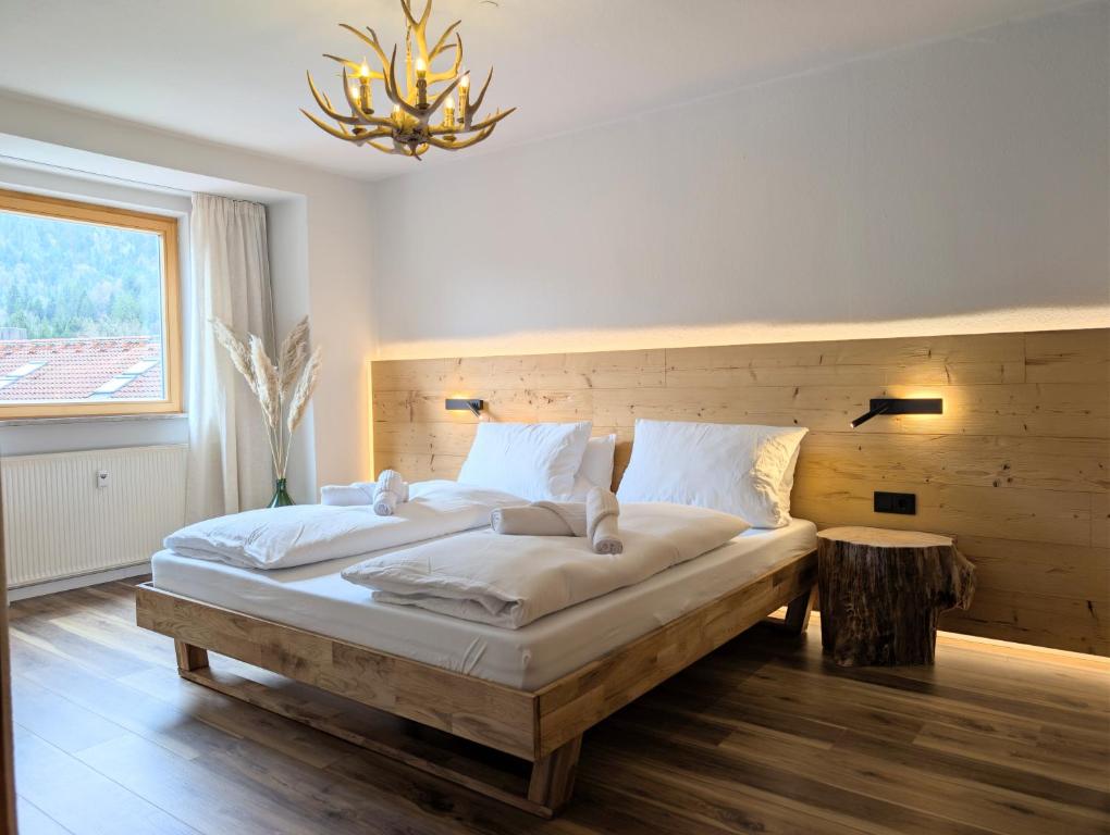 a bedroom with two beds and a chandelier at Chic Alpine Oasis in Oberammergau with Mountain View in Oberammergau