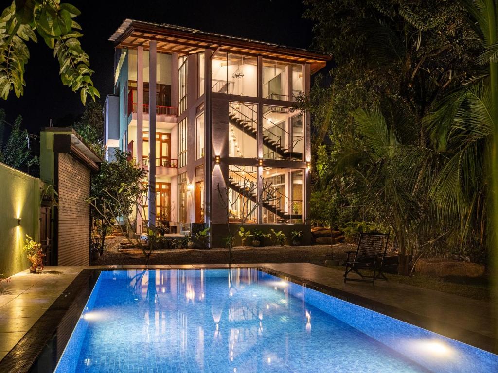 a house with a swimming pool at night at Mashmellow Resort and Spa in Galle