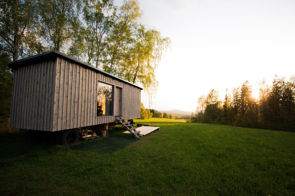 a tiny house sitting in the middle of a field at Maringotka pod Smrkem in Nové Město pod Smrkem