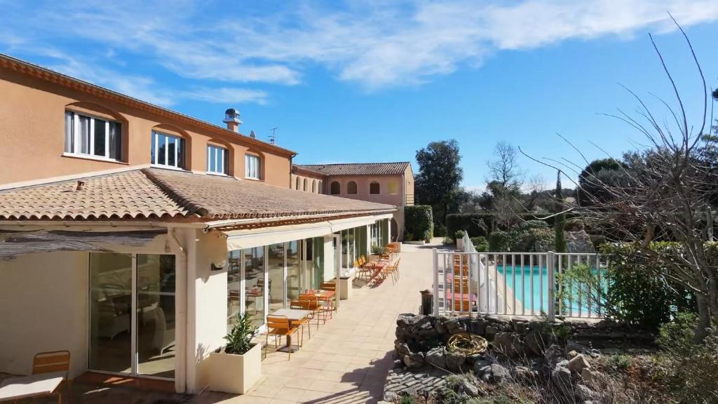 a villa with a swimming pool and a patio at Logis Hostellerie De L'Abbaye in Le Thoronet