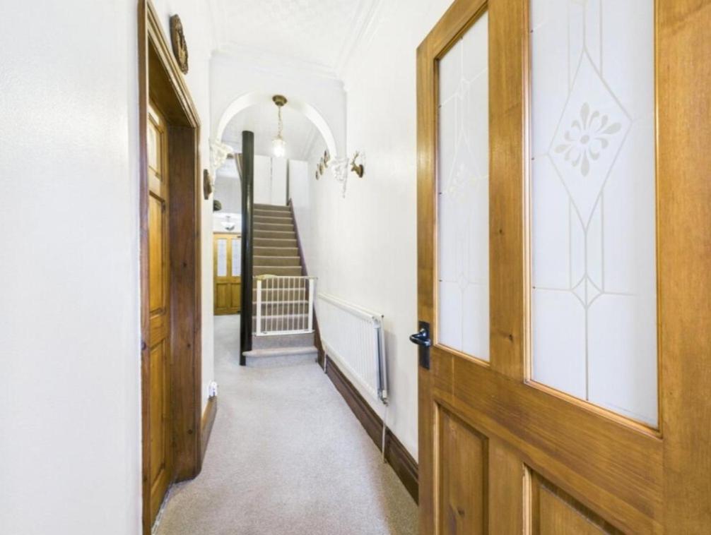 a hallway with a wooden door and a staircase at The Bishop Bolthole in Bishop Auckland
