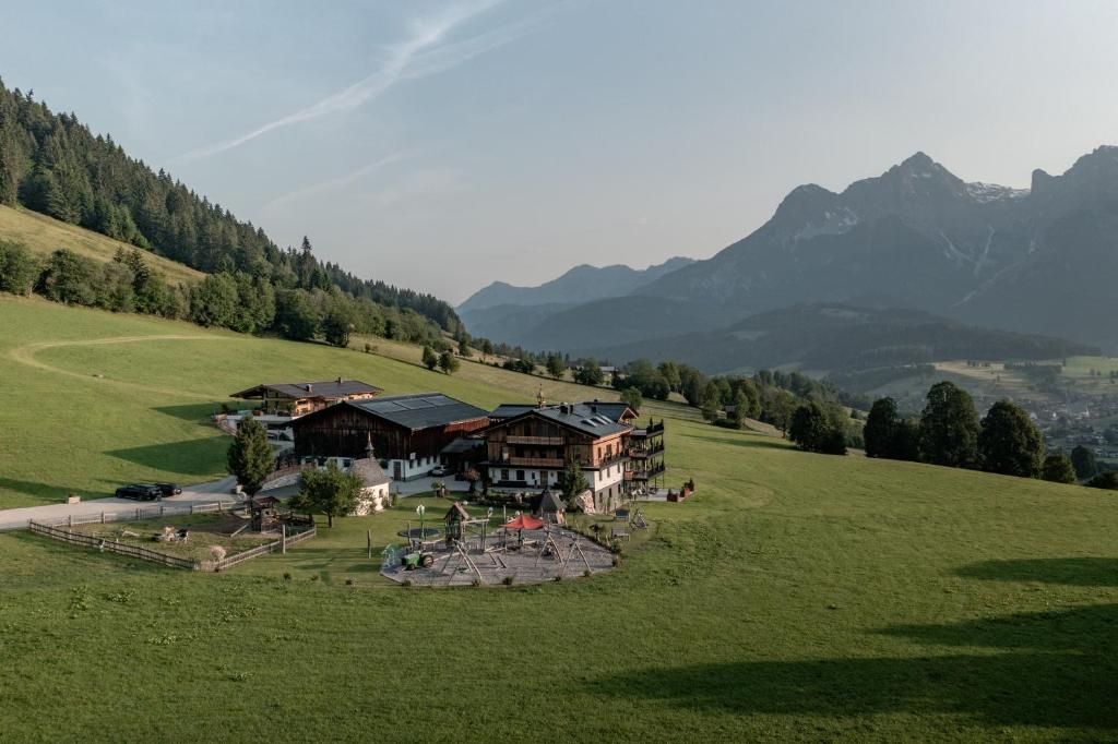 an aerial view of a house in a green field at Biohof Ebengut in Maria Alm am Steinernen Meer