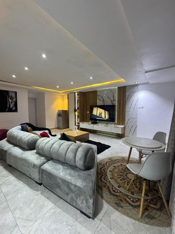 a living room with a large couch and a table at The Adun Grove in Lekki