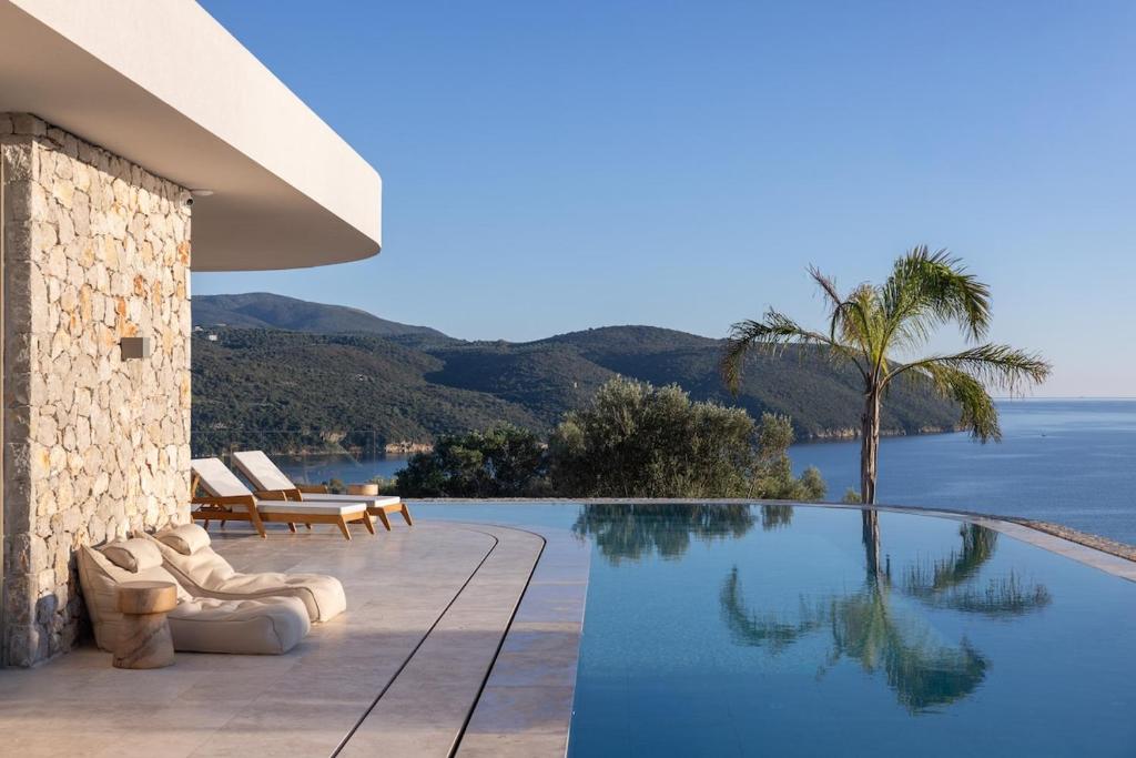 a swimming pool with a view of the ocean at Villa On the Rocks in Finikounta