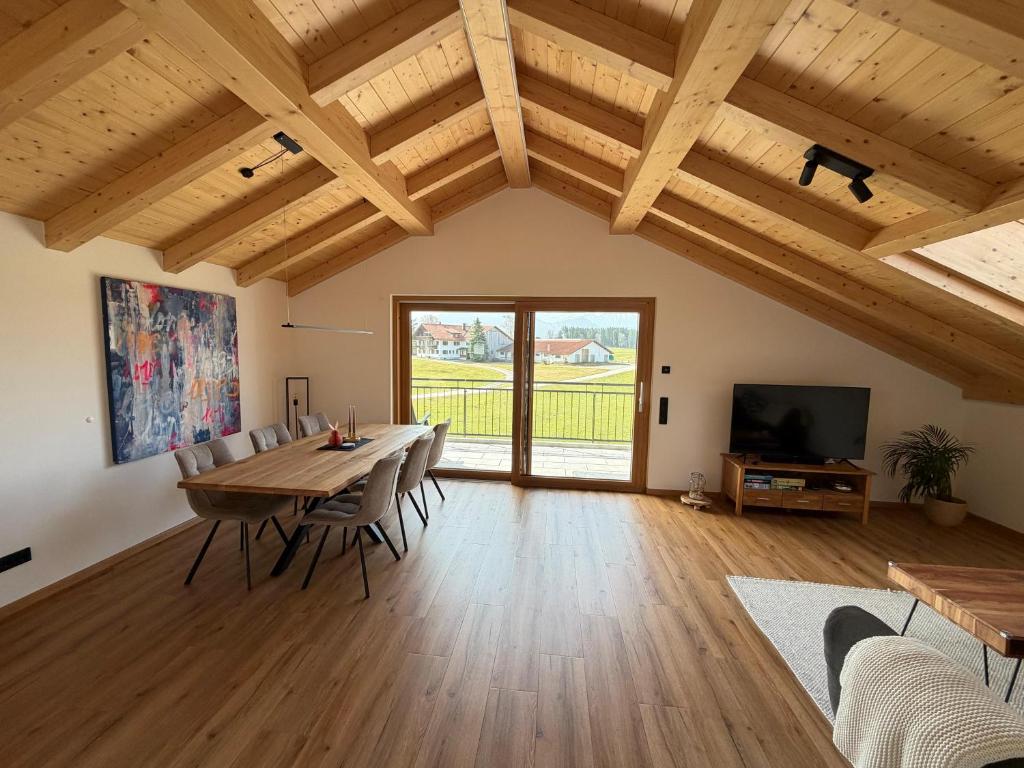 a living room with a wooden table and chairs at Gams im Glück in Hopferau