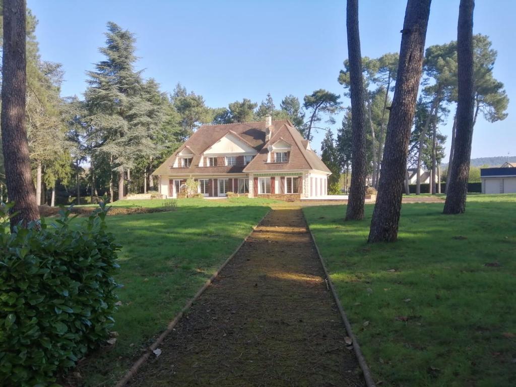 a house with a pathway leading into a yard with trees at Le toit d'éco pins in Le Luart