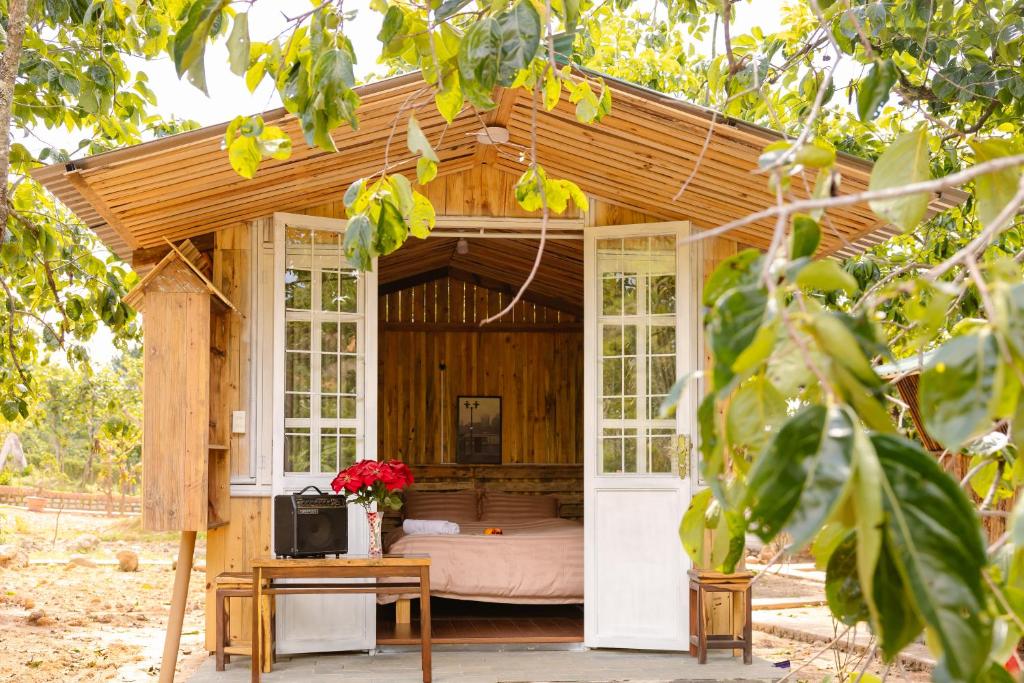 a tiny house with a porch and a bed in it at Làng Hương Village in Teurnoum