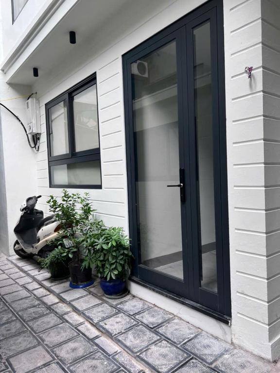a black door on the side of a house with plants at Moon Inn Apartment-self check in in Hanoi