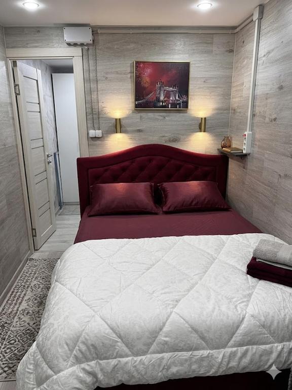 a bedroom with a large bed with a red head board at Main Street House in Chişinău