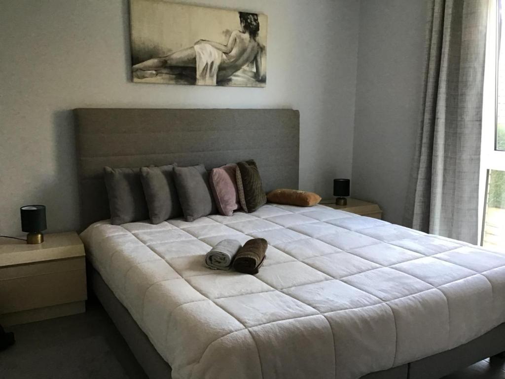 a bedroom with a large bed with two pillows on it at La casa in Tielt