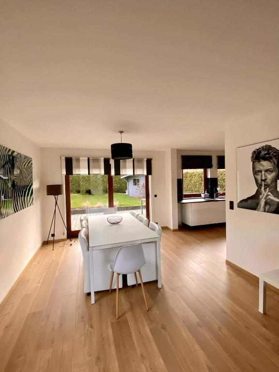 ein Wohnzimmer mit einem weißen Tisch und einem Stuhl in der Unterkunft La Cardamine in Marche-en-Famenne