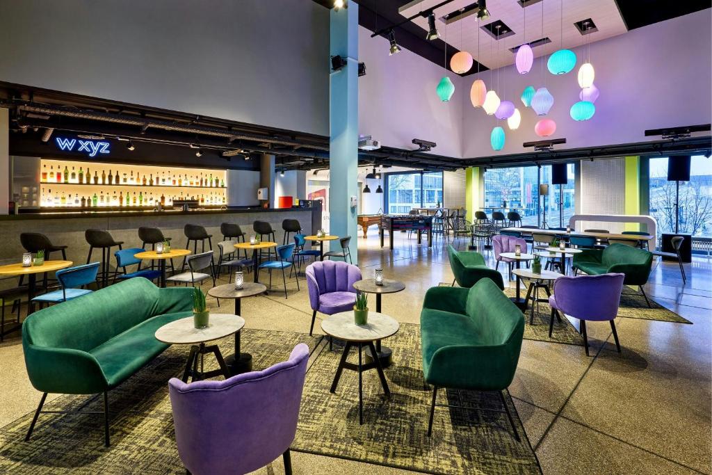 a restaurant with purple and green chairs and tables at Aloft by Marriott Stuttgart in Stuttgart