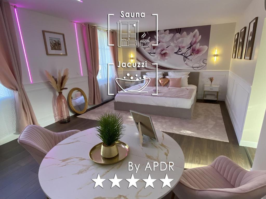 a room with a bed and a table with a laptop at Cocon Diamant - Nuit Romantique - Jacuzzi et Sauna - Hyper-Centre in Compiègne