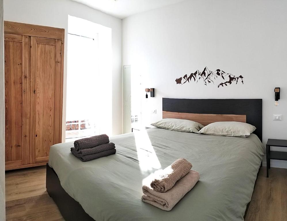 a bedroom with a large bed with towels on it at Camera con bagno privato in Tesero