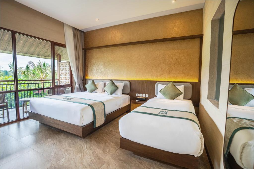 a bedroom with two beds and a balcony at Bumi Anyom Resort by Nexura in Pikatan