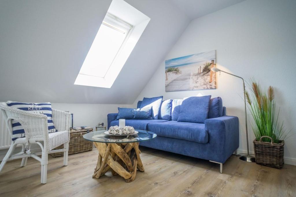 a living room with a blue couch and a table at Lister Tor 11 in List
