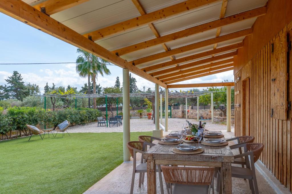 a wooden pergola with a table and chairs on a patio at Naus Limen in Marathi