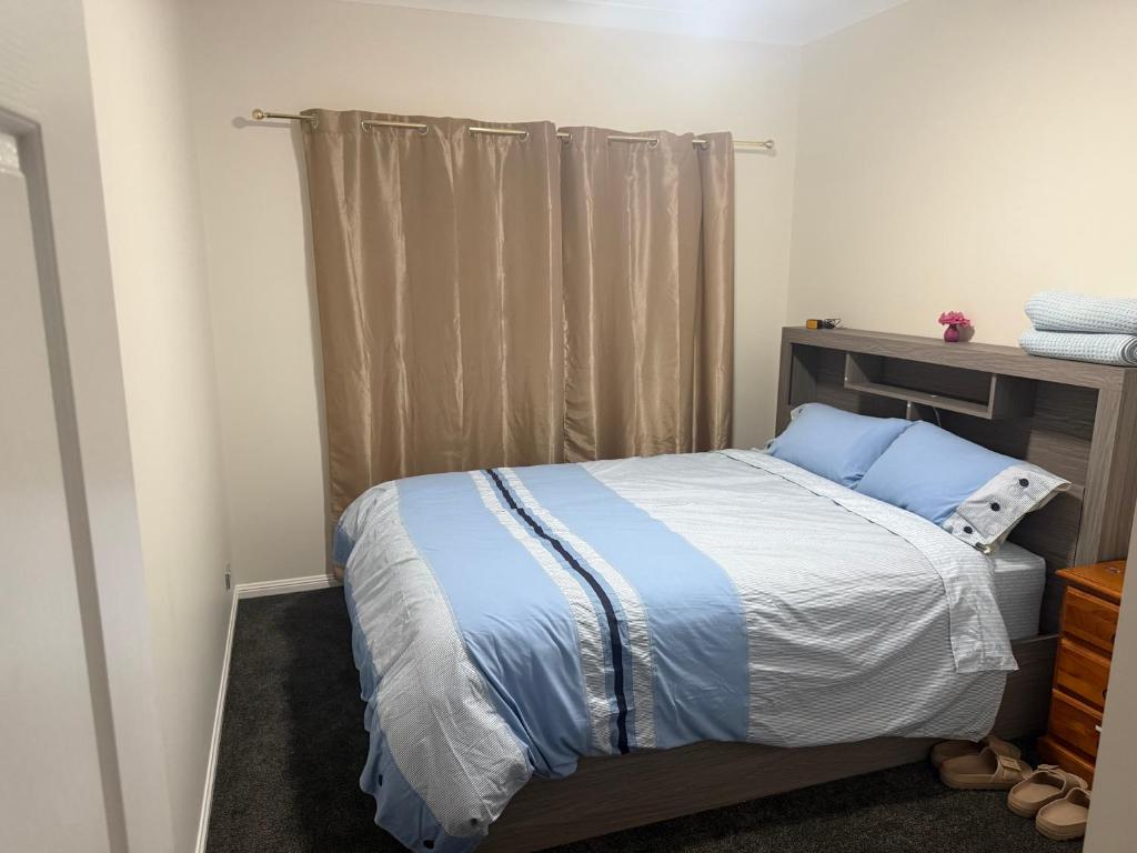 a small bedroom with a bed with blue pillows at Darra guest house in Brisbane