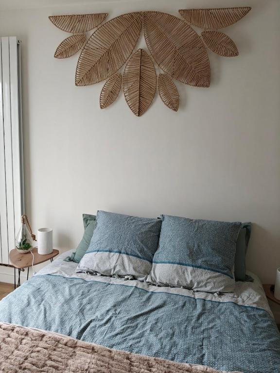 a bedroom with a bed with a large plant on the wall at TyCoCoon in Lannion