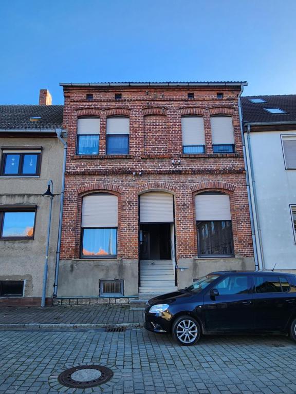 a black car parked in front of a brick building at Gröningen in Gröningen