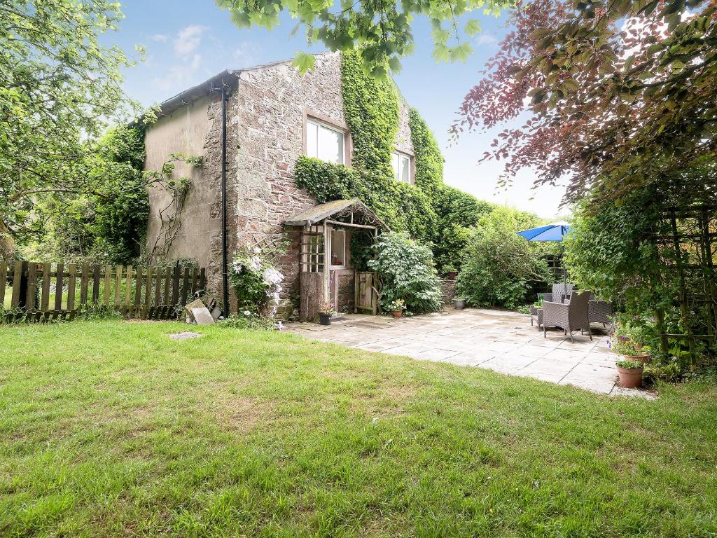 an old stone house with ivy growing on it at The Cottage in Gosforth
