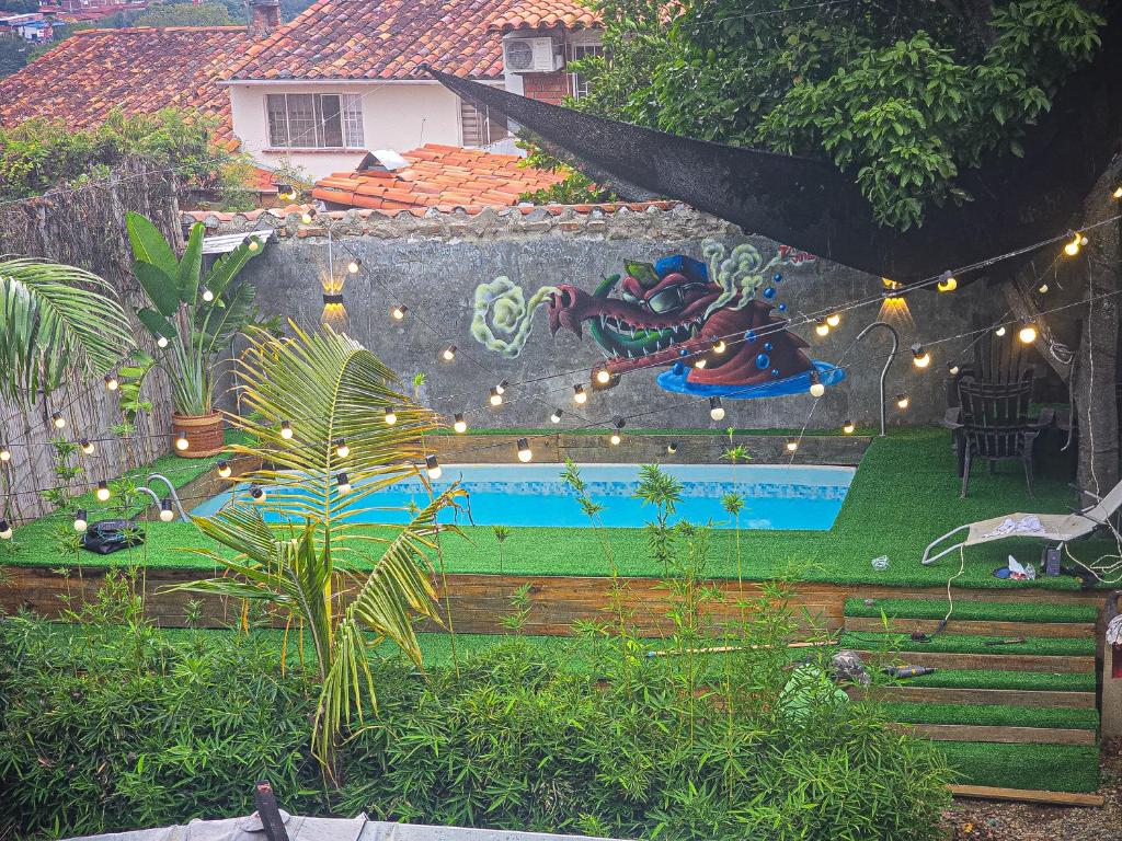 a backyard with a garden with a pool and lights at Urban Hostel Pool & Garden in San Gil