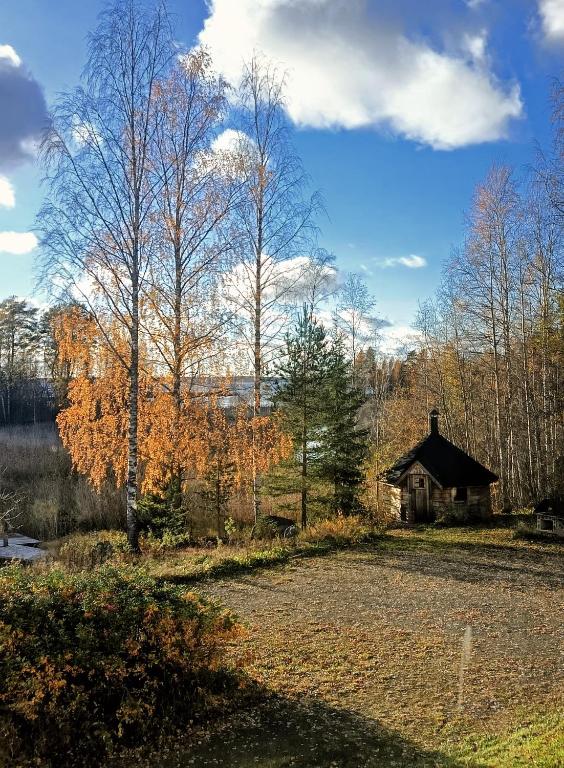 a house in the middle of a field with trees at Nivan Majoitus Nivan koulu in Joensuu