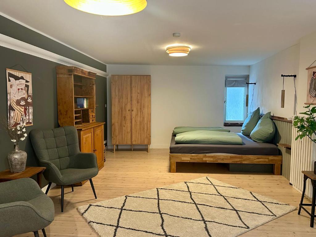 a bedroom with a bed and a couch and a chair at Stadtwohnung Hygge Home in Neustadt in Holstein