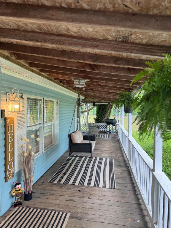 a porch with a hammock on a blue house at 3 bedroom River cabin retreat ! in Terre Haute