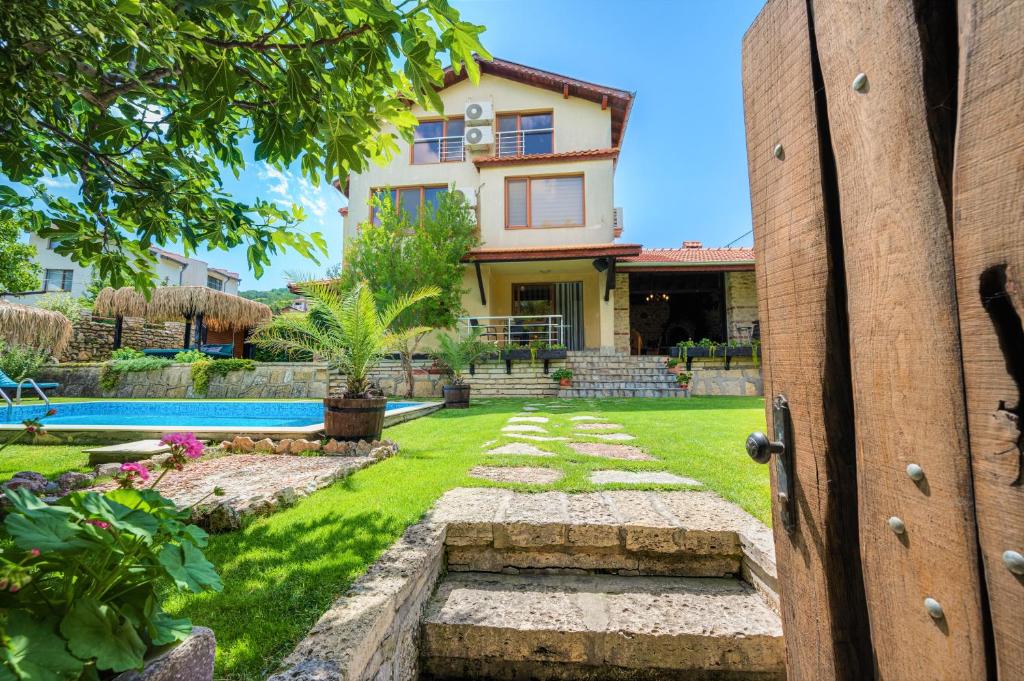 a house with a yard with a swimming pool at Villa Komitata-Pool and Jacuzzi in Balchik