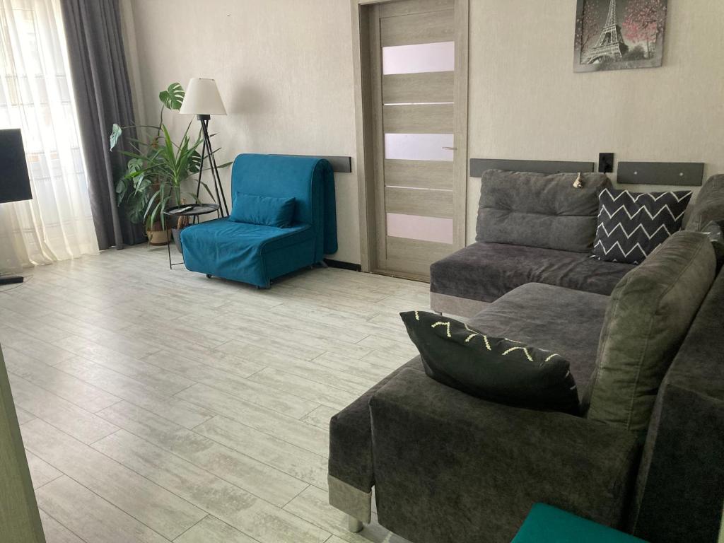 a living room with a couch and a blue chair at Apartment Artynova 29,світло завжди in Vinnytsya