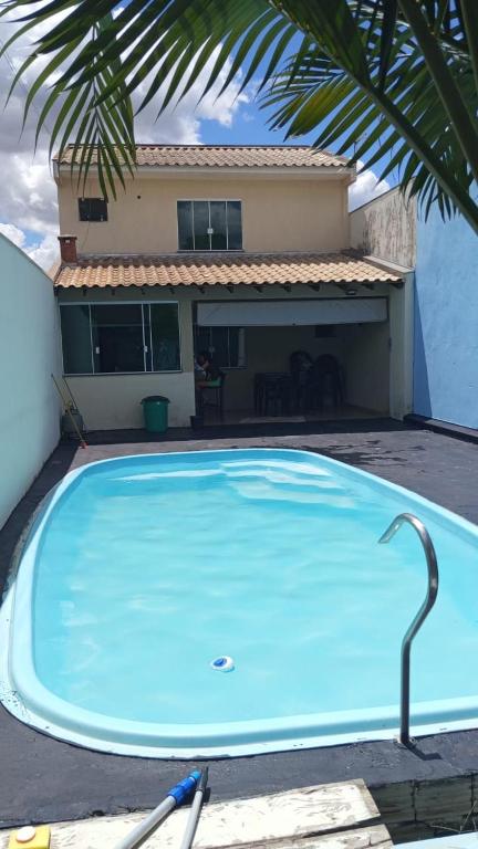 a large blue swimming pool in front of a house at Casa de lazer 3Y in Maringá