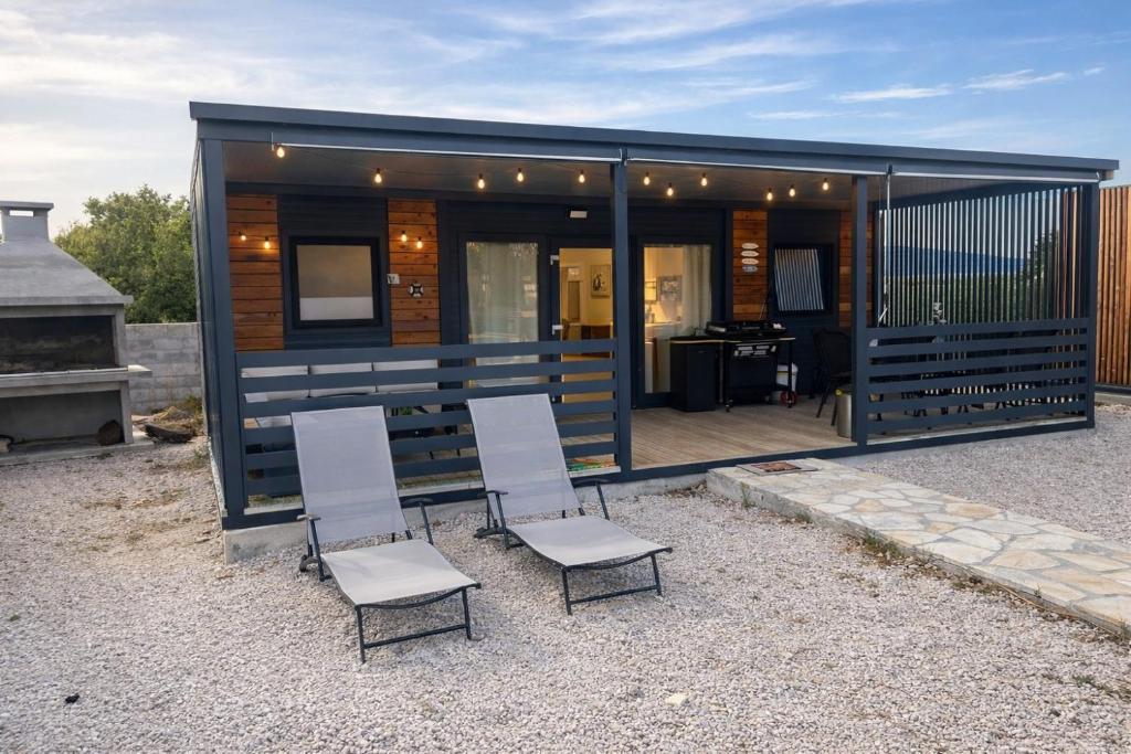 a group of chairs sitting in front of a tiny house at Adria Mobile Home in Pirovac