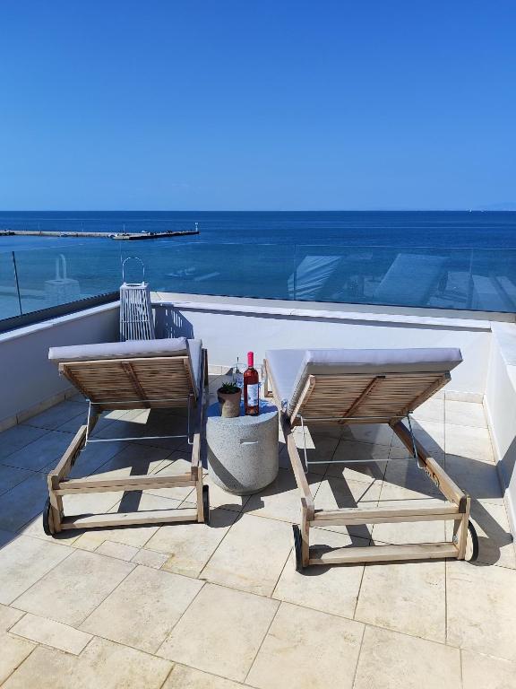 two chairs and a table on a patio overlooking the ocean at Vista mare by Oikies Rentals in Neoi Epivates